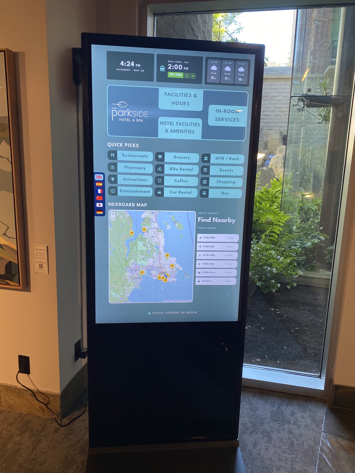 NexBoards touchscreen showing the Parkside Hotel & Spa guide beside a garden window in the lobby